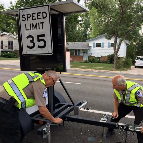 Bernie and Roger set up a speed sign to warn drivers to slow down